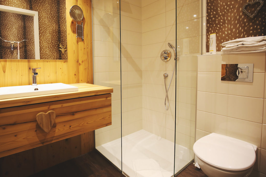 Modernes Bad mit Dusche, Waschbecken und Holzschrank
