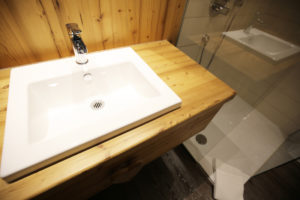 Weißes Waschbecken auf Holzschrank