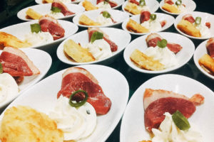 Weiße Schälchen mit Fleischscheiben, weißer Creme und Kartoffelkroketten