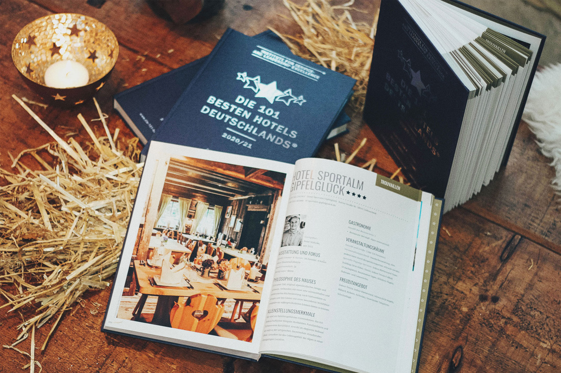 buch1 Aufgeschlagenes Buch in der das Hotel Sportalm Gipfelglück auf zwei Seiten erwähnt wird - Die 101 Besten Hotels Deutschlands