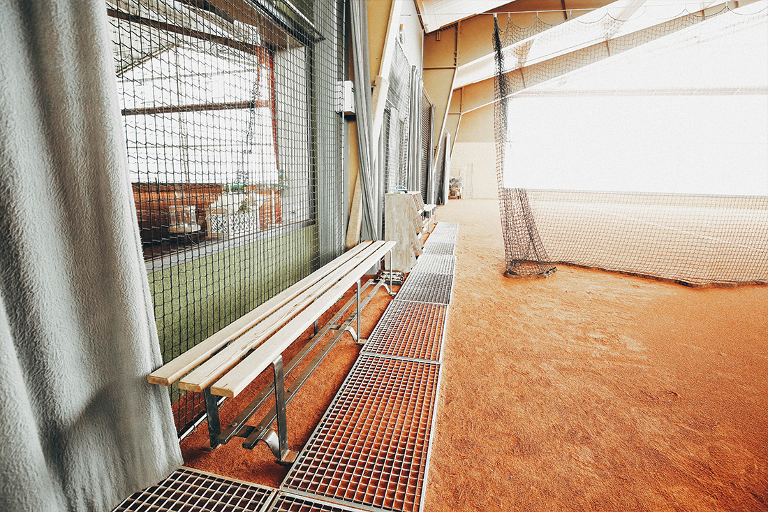 Sitzbank aus Holz am Rande eines Tennisplatzes mit Ascheboden in Lüdenscheid