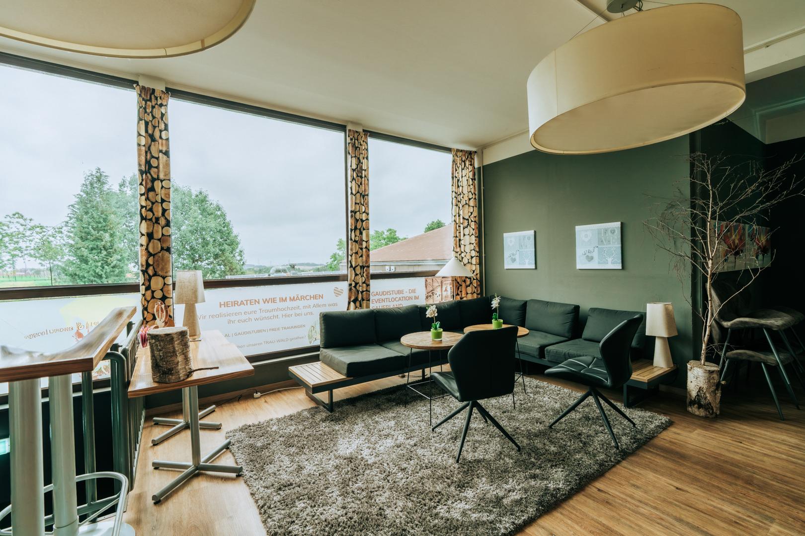 Moderne Business-Lounge mit Sitzbereich und großen Fenstern